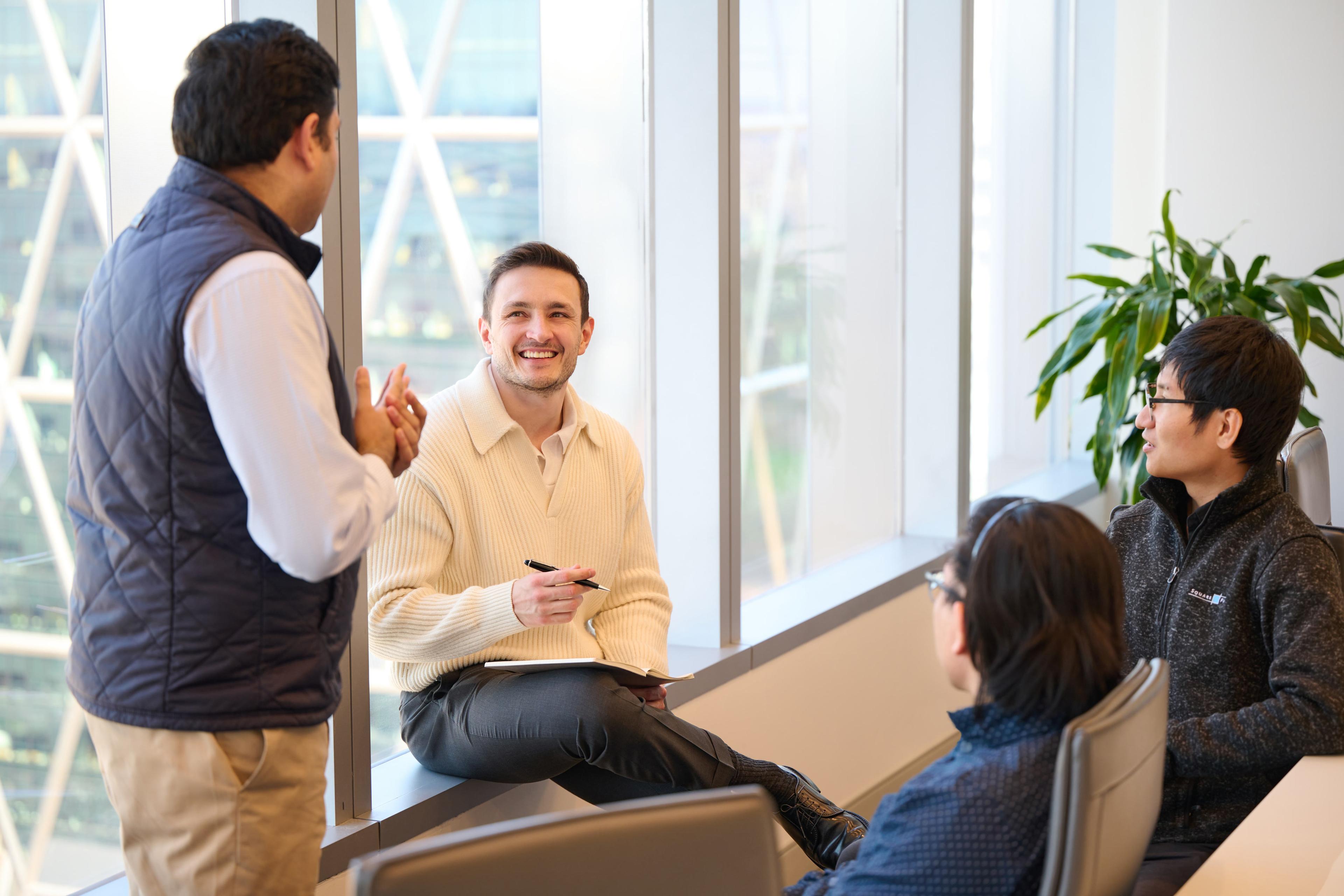 Employees helping an intern at their desk